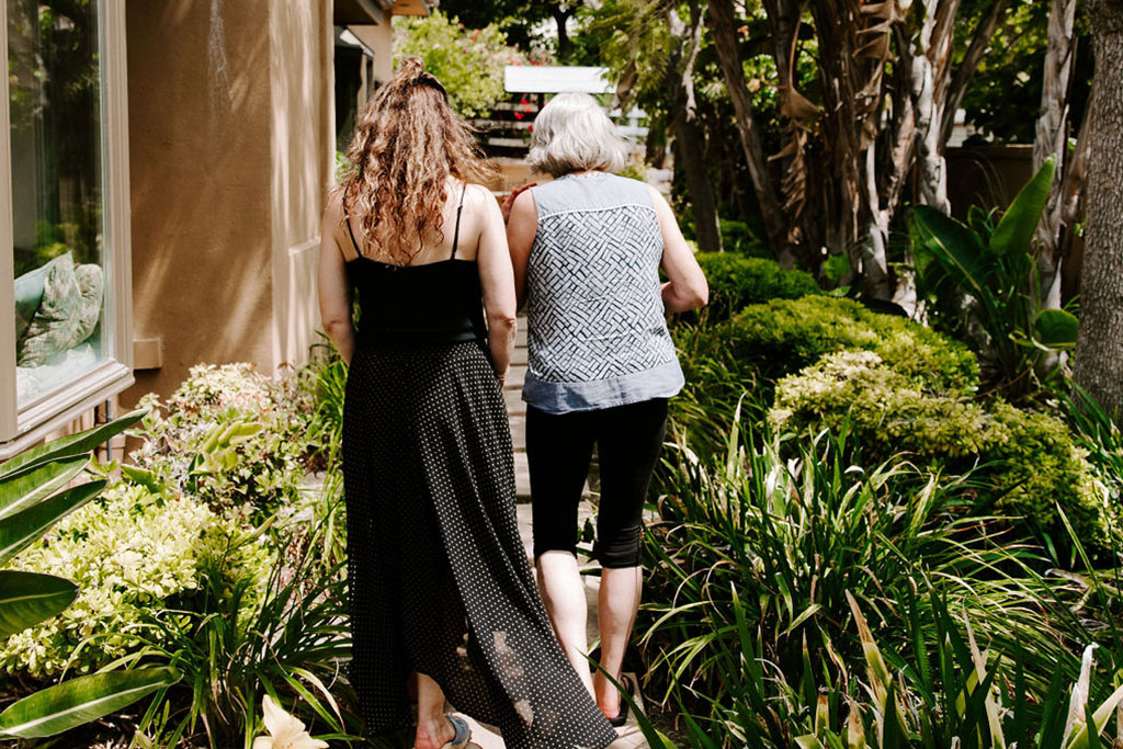 two women walking through beautiful outdoor area of rehab in orange county