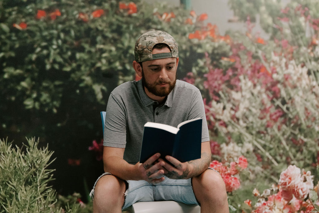 man reading a book outside at christian drug rehab