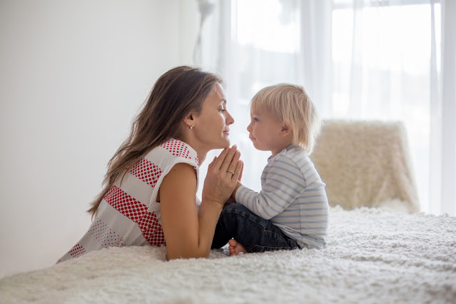 woman with her young son praying